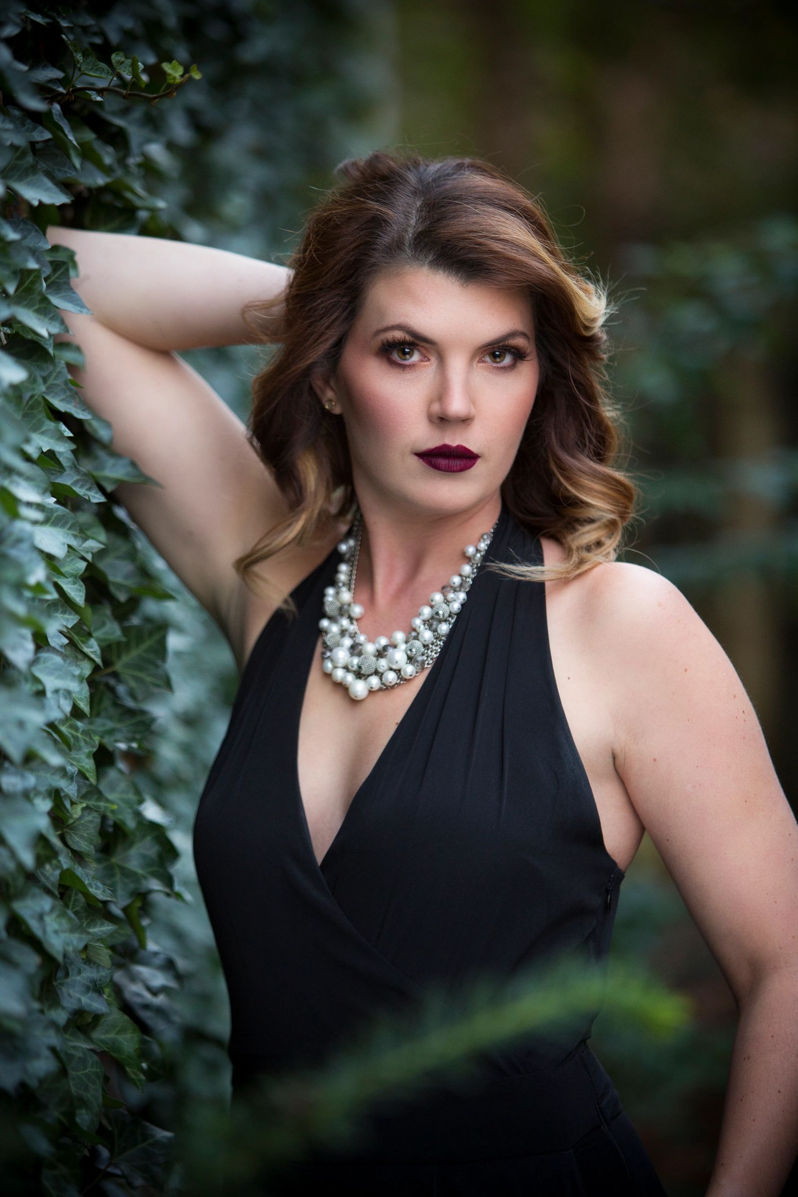 Brunette glamour styling against ivy backdrop